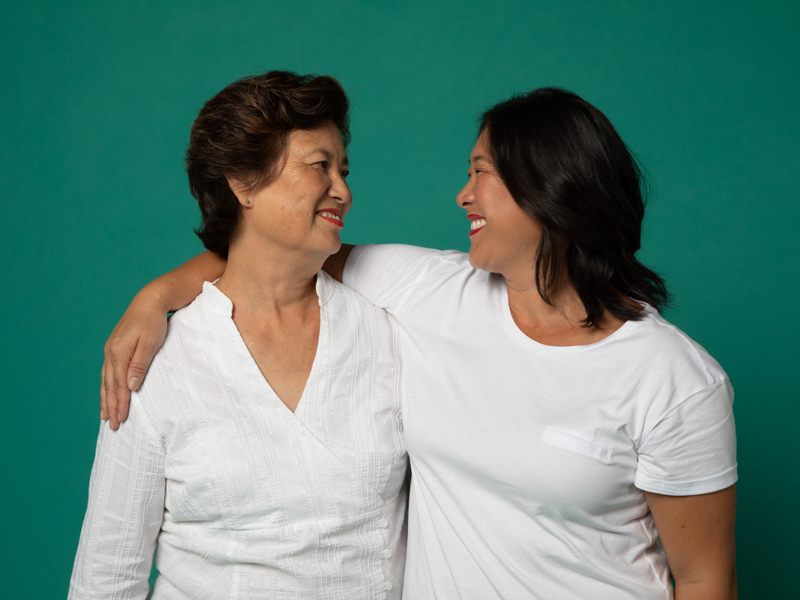 Image of an Asian mother and daughter smiling at each other